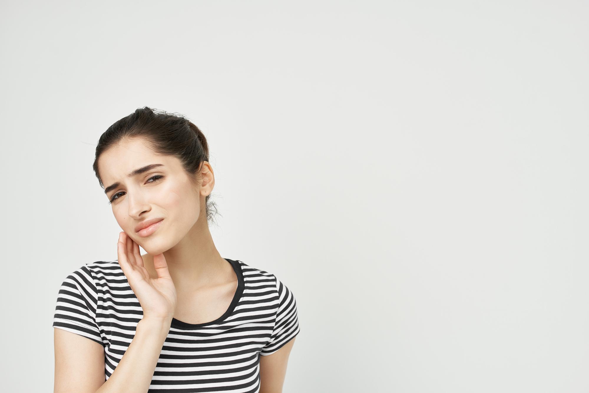 Woman holding her jaw from a toothache